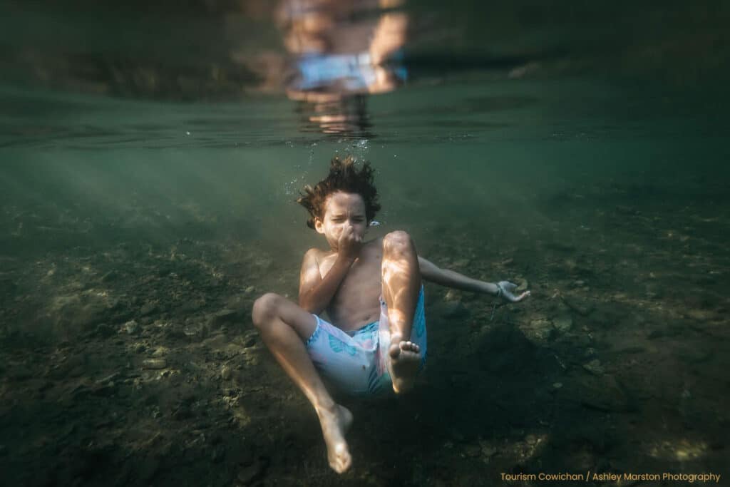 Child diving underwater in Lake Cowichan